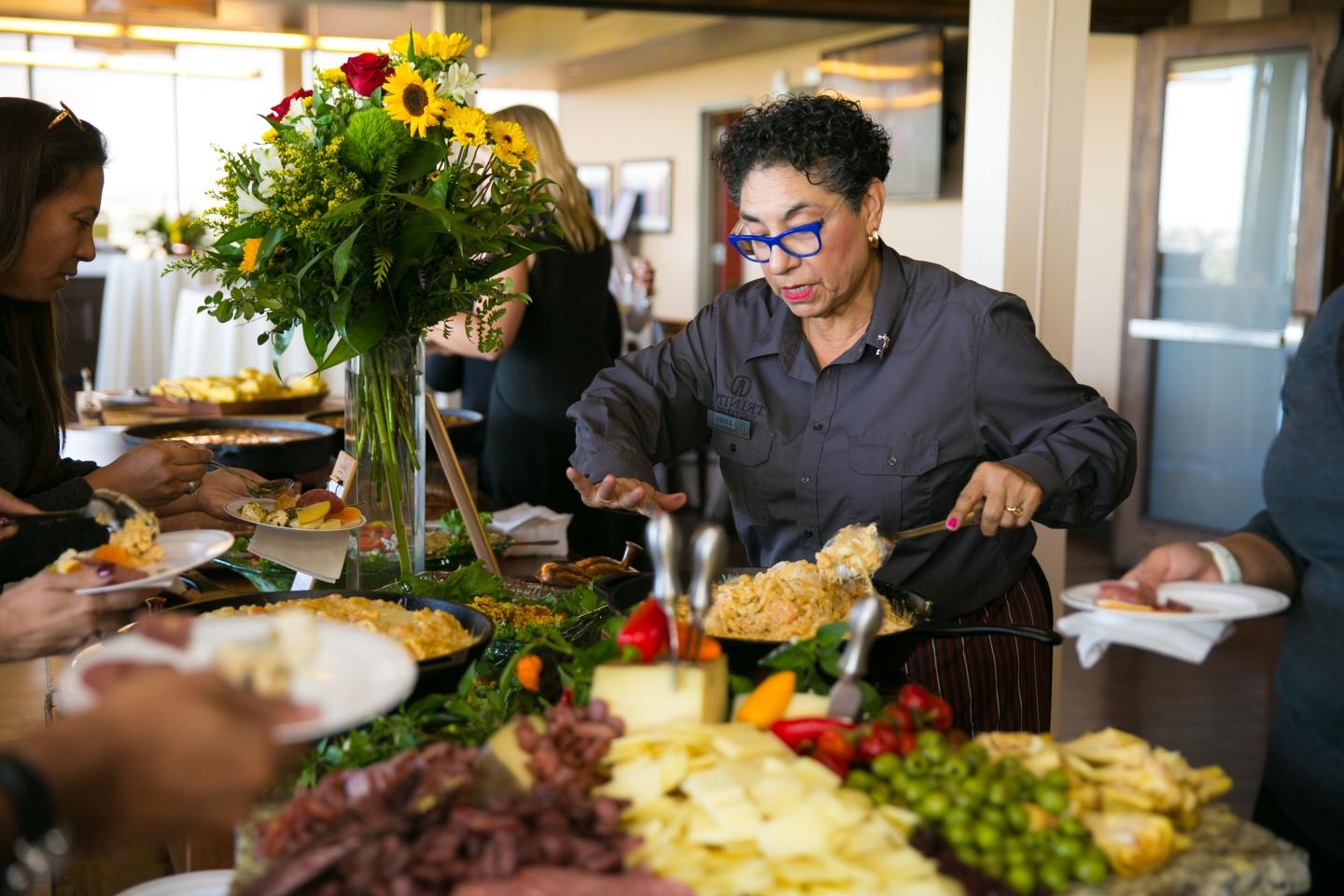 Woman  serving food to people at a buffet
