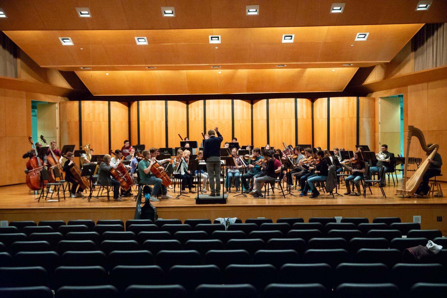 Orchestra practicing on stage in Ruth Taylor recital hall